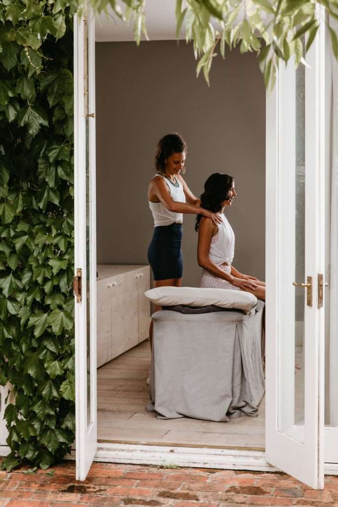 person receiving massage while seated on massage table